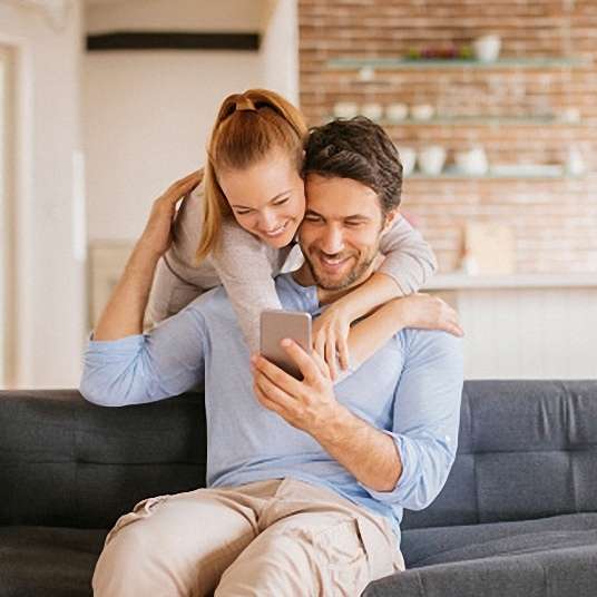 Young couple looking at smartphone Close up of a young couple using smart phone